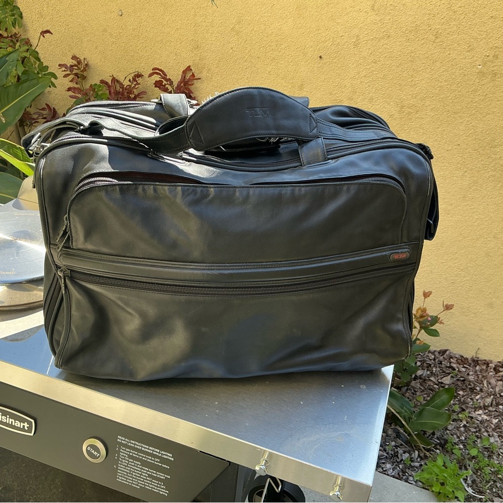 Tumi model 92122D4 black leather carry on bag with built in suiter EUC